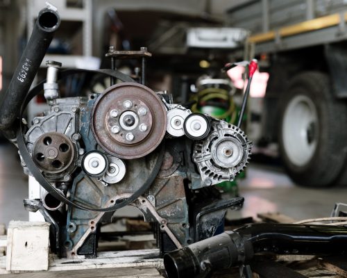 Part of mechanism or engine of large automobile inside technical repair workshop or hangar