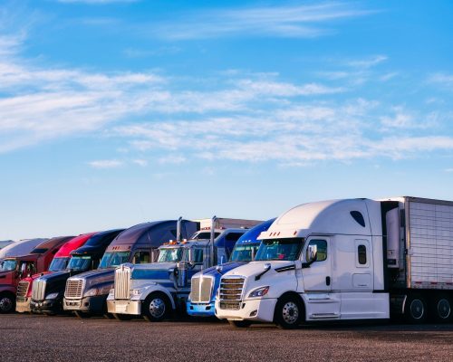 row-of-semi-trucks-parked-against-a-blue-sky-2026-03-16-22-57-46-utc