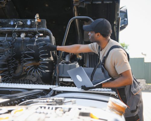 Truck repair service. Mechanic makes computer diagnostic of the semitruck.